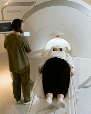 A patient undergoing an MRI scan with a healthcare professional present in a modern medical facility.